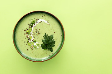 Bowl of tasty cream soup on color background