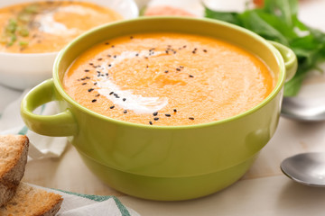 Pot of tasty cream soup on table