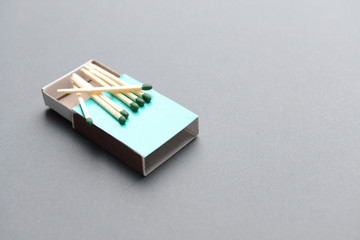 Box with matches on grey background
