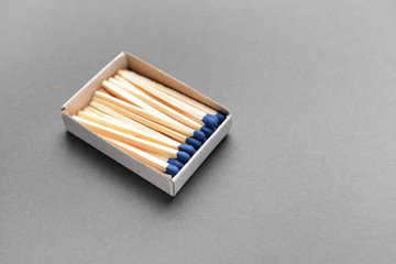 Box with matches on grey background