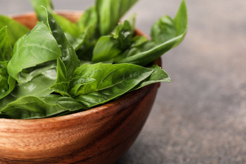 Bowl with fresh basil leaves on table, closeup