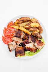 Pecenje with tomato salad and potatoes in restaurant