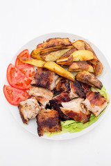 Pecenje with tomato salad and potatoes in restaurant