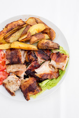 Pecenje with tomato salad and potatoes in restaurant