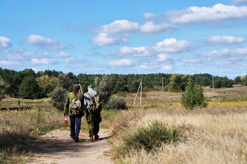 Fototapeta na wymiar Two men are walking along the path to the forest