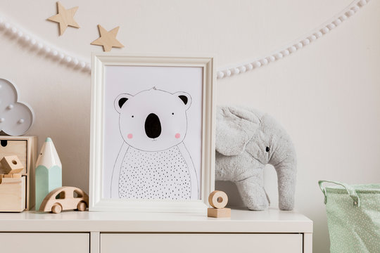 Stylish scandinavian newborn baby shelf with mock up photo frame, cotton basket, plush elephant, big mint crayon, wooden box and car. White garland and wooden stars on the wall. Home decor. 