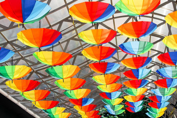Many colored umbrellas for urban decoration. rainbow umbrellas on the roof.