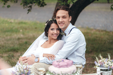 The first walk of the newlyweds, walking hug, love each other. girl in her hands holding flowers