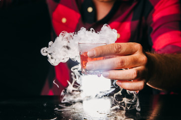 Barman serving red magic shot