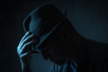 low key portrait of man with borsalino type hat