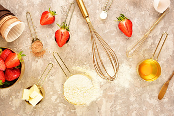 Background baking flat lay with golden devices, strawberries and flour.