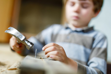 Little kid boy helping with toy tools on construciton site.