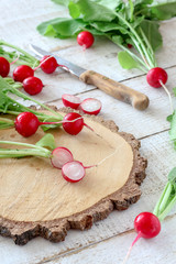 Cut radishes on a wooden cutting board on a white table