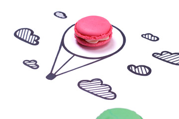 Macaroon and hand drawn air balloon and clouds on white background. Travel concept.