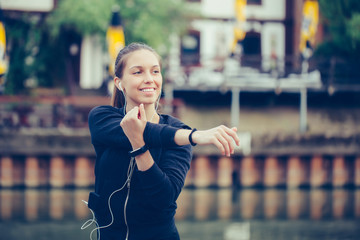 Young woman stretching her arms, by the river