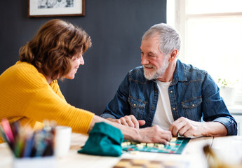 Senior couple playing board games in community center club.