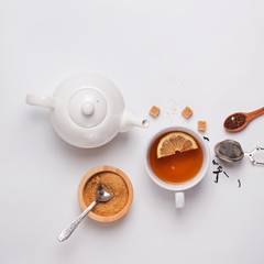Cup, teapot and sugar on the white background, top view