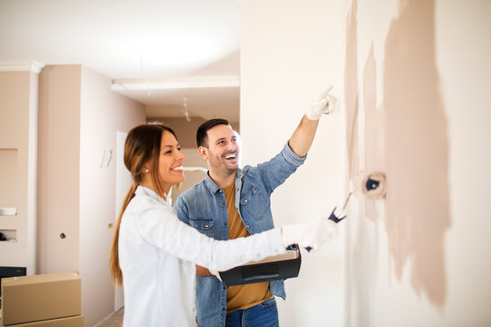 Young couple painting walls.