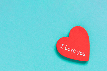 Fototapeta premium Red heart with text love you on blue background.