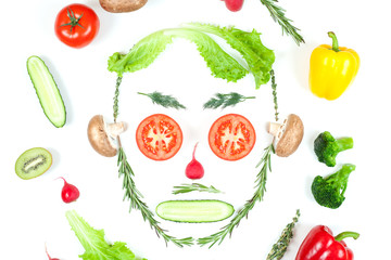 Funny face from different vegetables tomatoes, cucumber, radish, dill and rosemary isolated on white background. Healthy eating and vegan food concept. Kitchen