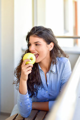 Young woman eats an apple