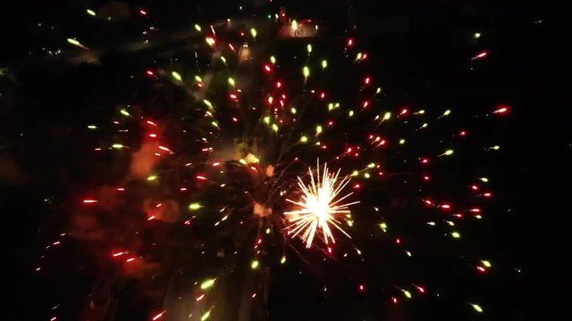 Fireworks display aerial black background exploding in night sky view. Fly over magic festive colorful fireworks top from above video by drone copter.