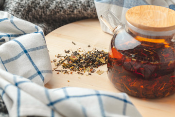 Earl Grey tea in glass tea pot on wood plate close up