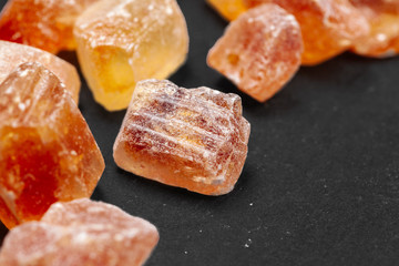 brown sugar rock organic crystalline close up on dark background