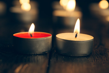 candles burning in darkness over black background. commemoration concept.