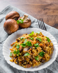 meat with Rice, mushroom and vegetables in white plate on wooden table background