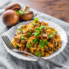 meat with Rice, mushroom and vegetables in white plate on wooden table background