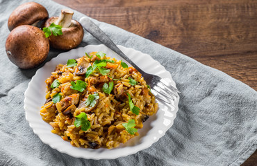 meat with Rice, mushroom and vegetables in white plate on wooden table background