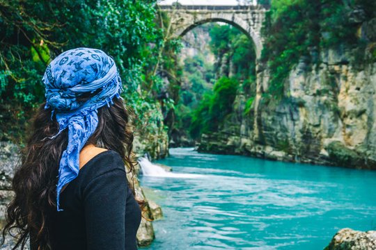 Amazing river and ancient bridge landscape from Koprulu Canyon in Manavgat, Antalya, Turkey. A woman watching the old bridge on river. Holiday and tourism concept