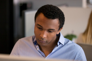 Close up African American businessman using laptop, looking at screen