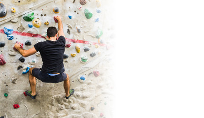 Man practicing rock climbing on artificial wall indoors. Active lifestyle and bouldering concept with copy space.