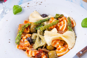 colorful farfalle with green asparagus olives and parma ham