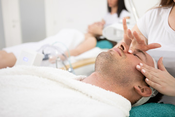 Obraz na płótnie Canvas Man in cosmetic spa salon enjoy in facial massage