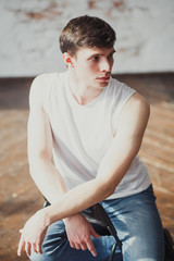 portrait of a young man in jeans and a sleeveless jacket