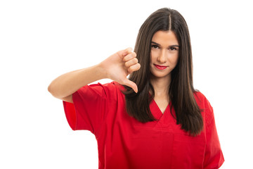 Portrait of beautiful nurse wearing red scrubs showing thumb down