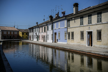 Plakat Colorful houses reflected in the waters of the canal in Comacchio, Emilia Romagna, Italy. 