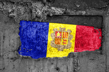 The flag of Andorra on a dirty wooden surface, built into a concrete base, with scuffs and...