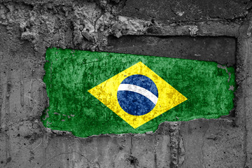 The flag of Brazil on a dirty wooden surface, built into a concrete base, with scuffs and...