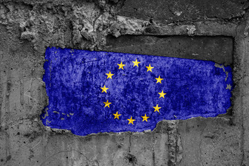 The flag of European union on a dirty wooden surface, built into a concrete base, with scuffs and scratches. Loss or destruction conception.