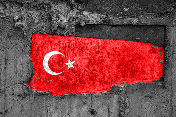 The flag of Turkey on a dirty wooden surface, built into a concrete base, with scuffs and...