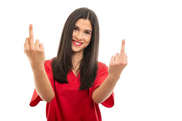 Portrait of beautiful nurse wearing red scrubs showing middle fingers