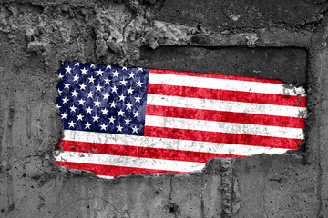 The flag of United States of America on a dirty wooden surface, built into a concrete base, with scuffs and scratches. Loss or destruction conception.