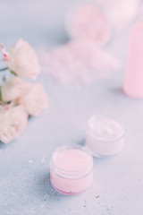 Obraz na płótnie Canvas Spa and body care products. Aromatic rose bath Sea Salt, cream, flowers on the grey background. Beauty skin care. Spa treatment