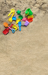 Fototapeta na wymiar Multi-colored toys on the sand. Summer holiday beach