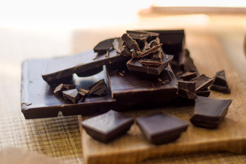 Cut chocolate pieces on the wooden background