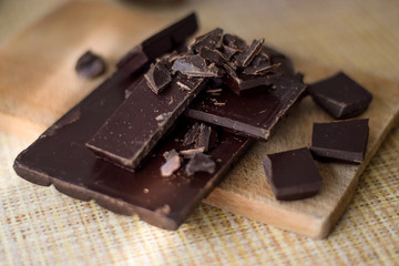 Cut chocolate pieces on the wooden background